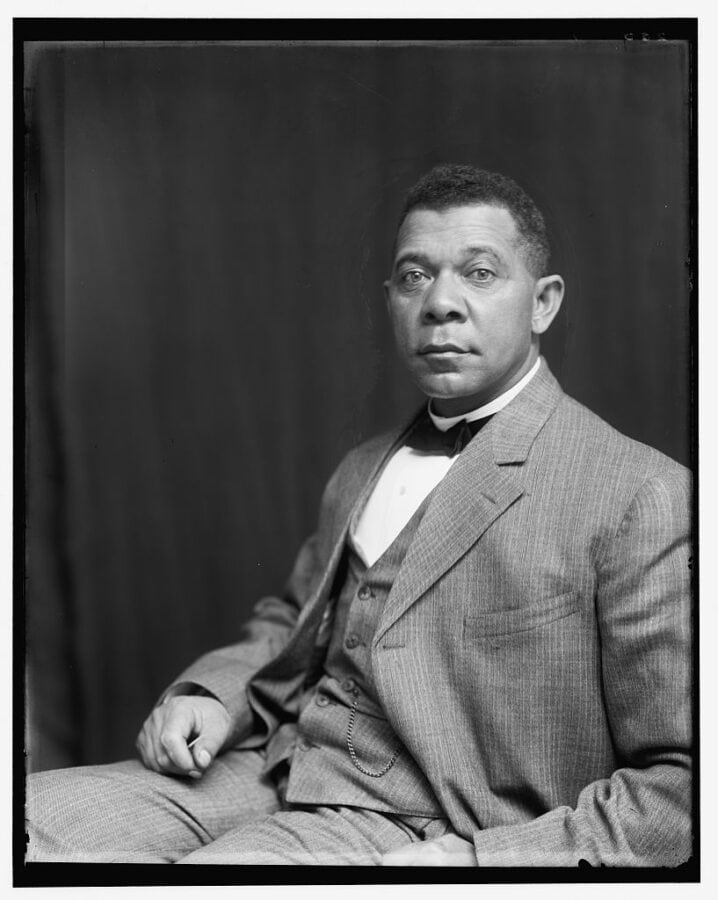 An African American man wears a three-piece suit and appears to be about 40 years old. He is sitting for a photographic portrait and looks directly at the camera.