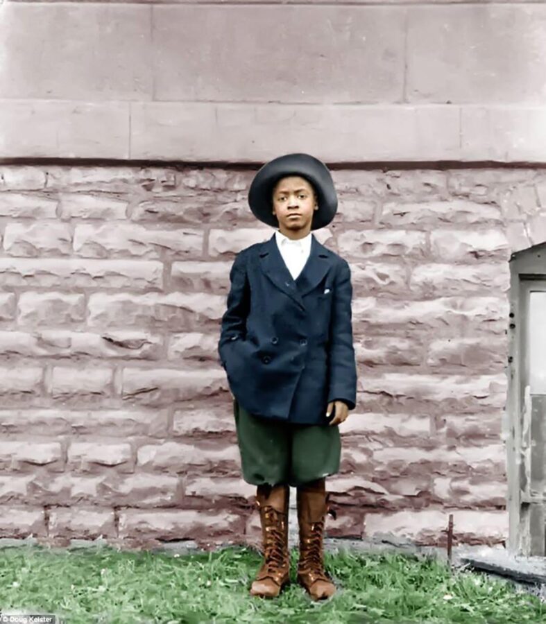 This is a colorized photo of the previous image. The boy now has a blue jacket, green knickers, and brown boots.